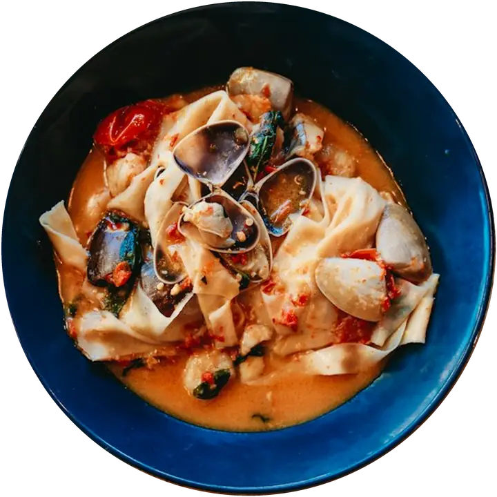 Pappardelle ai frutti di mare in una ciotola blu, viste dall'alto