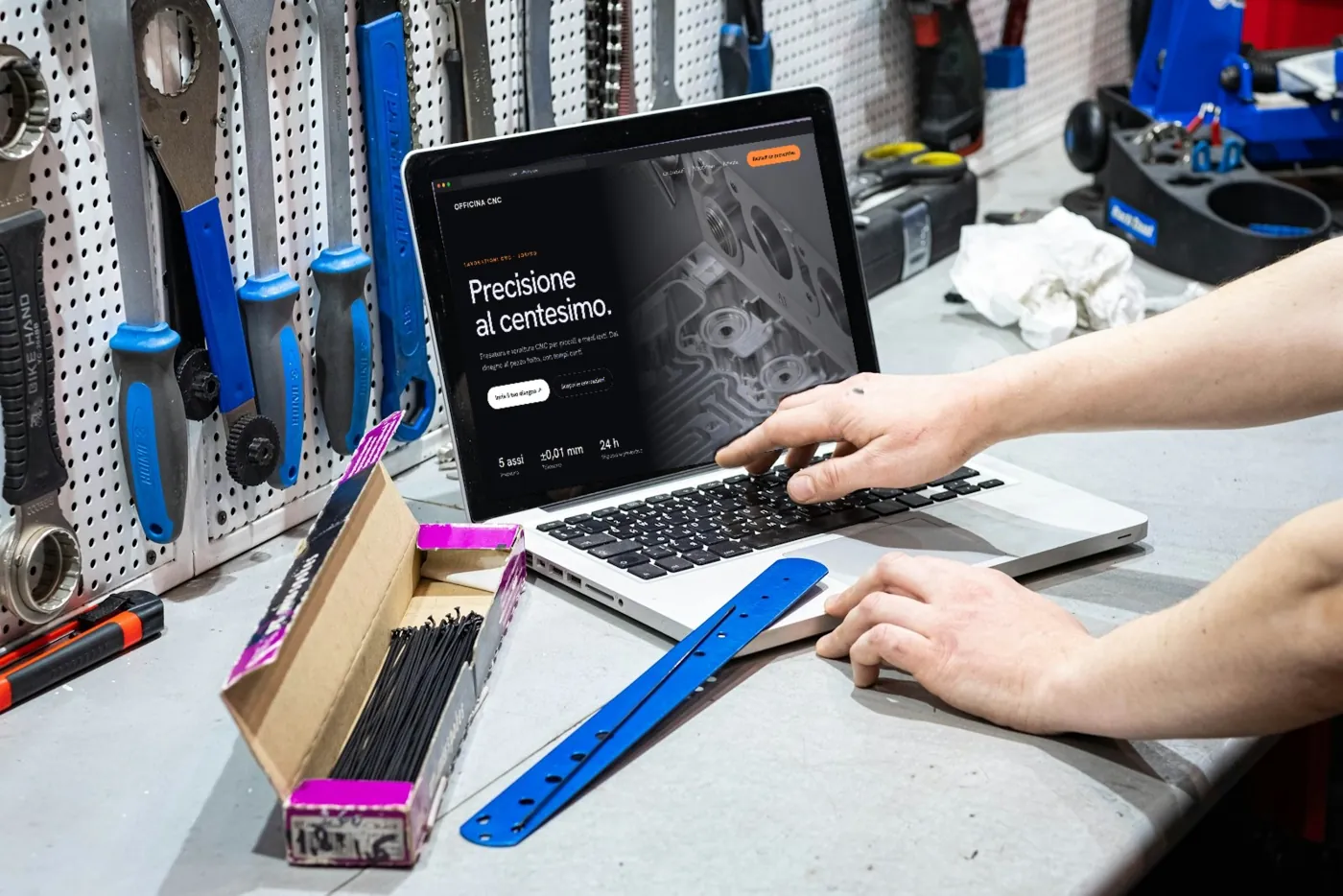Laptop in un’officina con utensili appesi