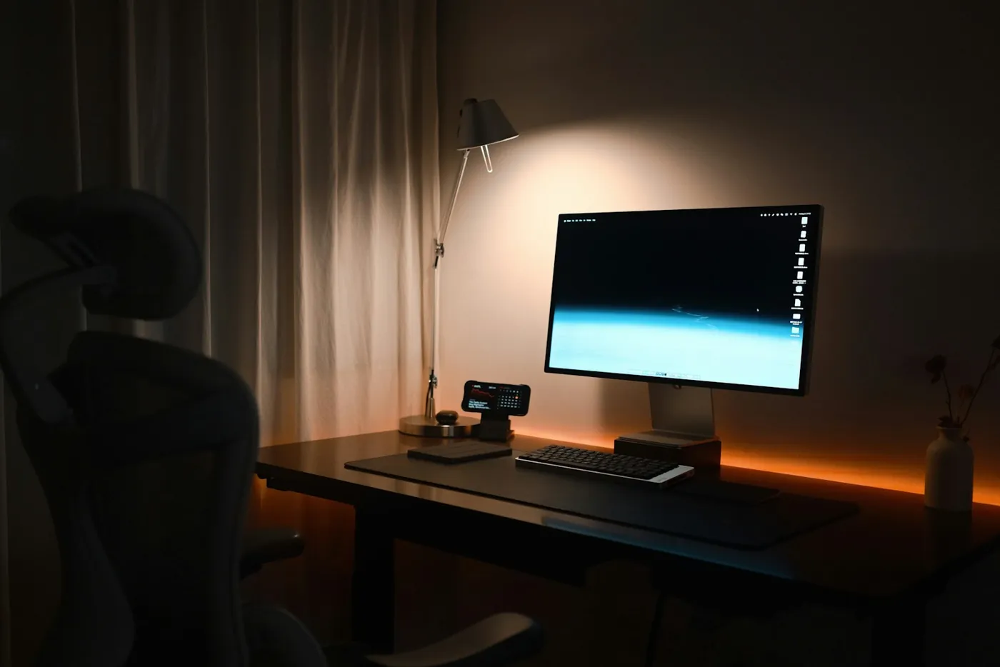 Una postazione di lavoro moderna con monitor, al buio